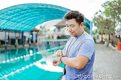 a swimming coach with a stopwatch on his neck standing on a watch Stock Photo