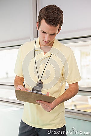 Swimming coach writing on clipboard Stock Photo