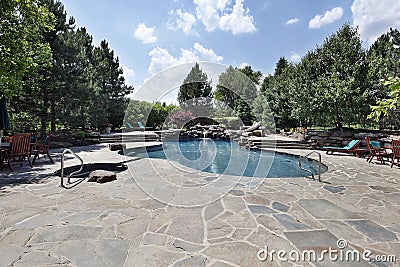 Swimming pool with large stone patio Stock Photo