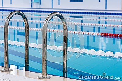 Swimming pool with marked red and white lanes. Empty swimming pool without people with quiet standing water. Stock Photo