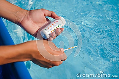Swimming pool Ph checking. Green water, green pool problem as background. Stock Photo