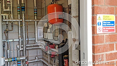 A swimming pool plant heating room with warning sign outside Stock Photo