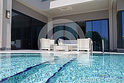 swimming pool with white outdoor furniture on modern luxury resort Stock Photo