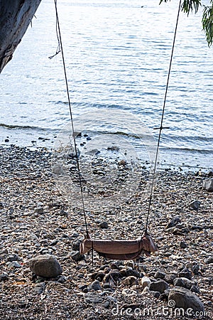 A swing attached to a tree and overlooking the Sea of Galilee Stock Photo