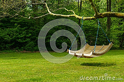 Swing bench in lush garden Stock Photo