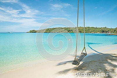 Swing hang from coconut tree over beach Stock Photo