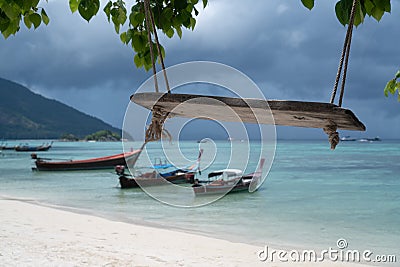 Swing hang from tree over tropical beach and sky background Stock Photo