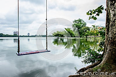 swing seat beside lake under the tree Stock Photo