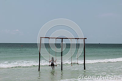 Swinging on a swing at ocean Stock Photo