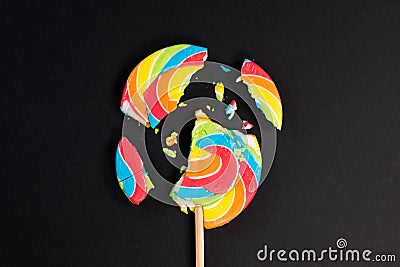 Swirl round broken lollipop on black background. Stock Photo