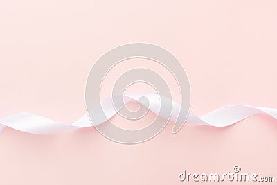 Swirled curly white silk ribbon on pastel pink background. Sewing wedding engagement fashion crafts hobby Stock Photo