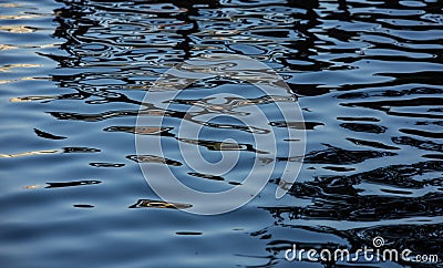 Swirls and ripples in Water with Pantone Blue and Gold Reflections Stock Photo