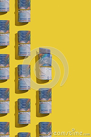 Swiss franc rolls on yellow background Stock Photo
