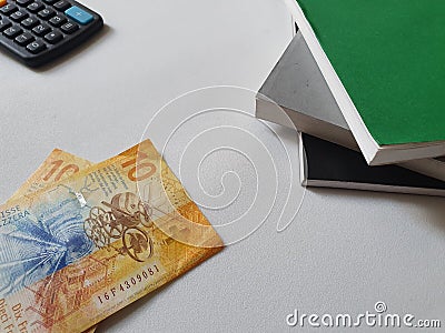 swiss money, books and calculator on white background Stock Photo