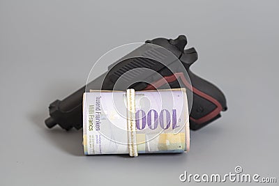 Swiss thousand francs in a roll and gun Stock Photo