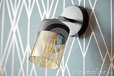 switched off stylish wall light, bedside lamp on the blue wall close-up Stock Photo