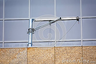Swiveling davit arm is attached to the building rooftop structure Stock Photo