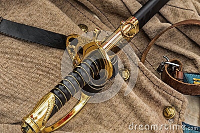 The sword is black the golden handle of the civil war of 1861-1865 lies against the background of the traditional soldier uniform Stock Photo
