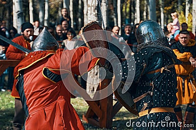 A sword fight in front of a crowd of spectators. Editorial Stock Photo