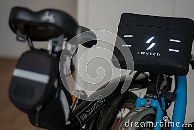 Swytch kit electric Brompton bike. A Black and blue Brompton folding bicycle Editorial Stock Photo