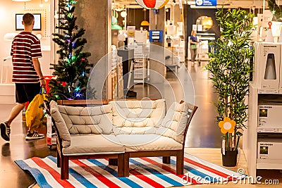 Male customer near the white sofa on striped rug at IKEA showroom on Christmas season Editorial Stock Photo