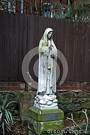 Nun statue in Peace Park of St. Canice`s Parish, praying for the repose of the soul Editorial Stock Photo