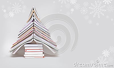 Symbol Christmas tree from a colorful books on grey background. Stock Photo