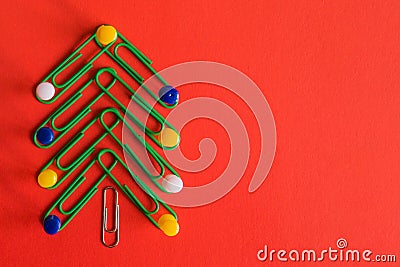 Symbol Christmas tree made of stationery, paper clips, office supplies on red background. new year`s concept in office Stock Photo