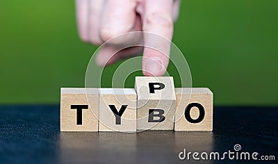 Symbol for correcting a typo. Hand turns dice and corrects the expression tybo to typo Stock Photo