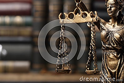 Symbol of fair treatment under law. Statue of Lady Justice near books, closeup with space for text Stock Photo