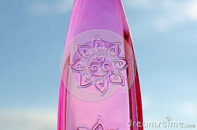 Symbol Happiness on a pink glass bottle against a blue sky. Stock Photo