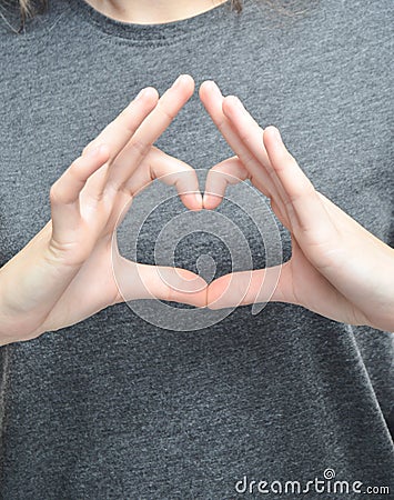 A symbol of the heart with the fingers of a female hand. Stock Photo