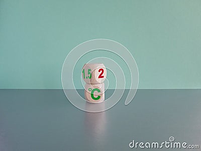 Symbol for limiting global warming. Turned a cube and changed the expression 2 C to 1.5 C, or vice versa. Beautiful grey table, Stock Photo