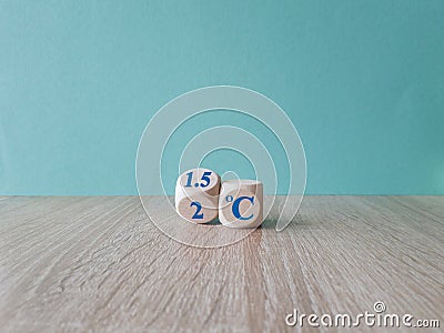 Symbol for limiting global warming. Turned a cube and changed the expression 2 C to 1.5 C, or vice versa. Beautiful wooden table, Stock Photo