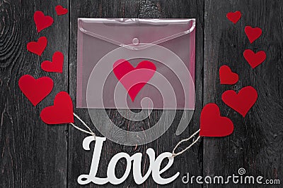 White letters Love with ropes and with red hearts, like balloons. Pink envelope with a heart inside Stock Photo