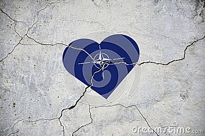 The symbol of the national flag of NATO in the form of a heart on a cracked concrete wall Stock Photo