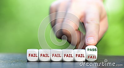 Symbol for never giving up. Hand turns dice and changes the word fail to pass Stock Photo