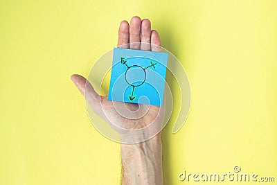 Symbol of transgender painted on a sticker in male hand on a yellow background Stock Photo