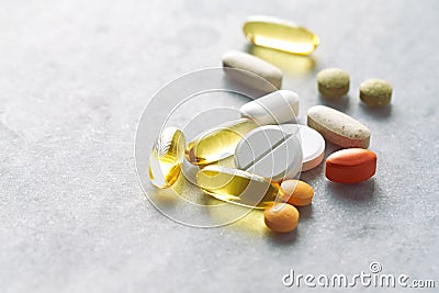 Assorted natural dietary supplements and vitamins on gray background Stock Photo