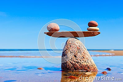 Symbolic scales made of stones on the sea background. Concept of harmony and balance Stock Photo