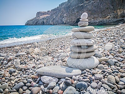 Symbolic scales of stones against the background of the sea and blue sky. Concept of harmony and balance. Pros and cons concept. Stock Photo