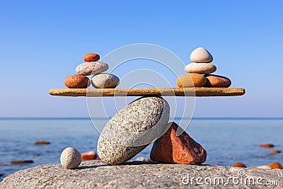 Symbolic scales of the stones against the sea. Pros and cons concept Stock Photo