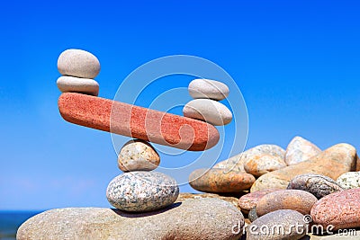 Symbolic scales from stones. The disturbed equilibrium. Imbalance concept. Stock Photo