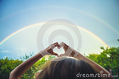 Symbolism of love, rainbow sky, love. heart shaped hands and rainbow in the sky. double rainbow Stock Photo