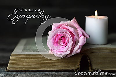 Sympathy card with burning candle and rose on open book Stock Photo