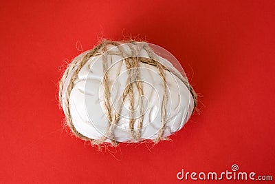 Symptom or manifestation of severe headache concept photo. Figure of human brain tied around of rope, located on red background, s Stock Photo