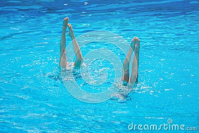 Synchronised swimming. Beautiful lean female legs in the water of a swimming pool. Concept of beauty, artistry Stock Photo