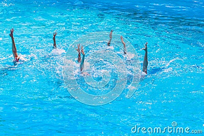 Synchronised swimming. Beautiful lean female legs in the water of a swimming pool. Concept of beauty, artistry Stock Photo