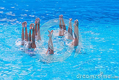 Synchronised swimming. Beautiful lean female legs in the water of a swimming pool. Concept of beauty, artistry Stock Photo