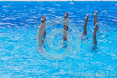 Synchronised swimming. Beautiful lean female legs in the water of a swimming pool. Concept of beauty, artistry Stock Photo